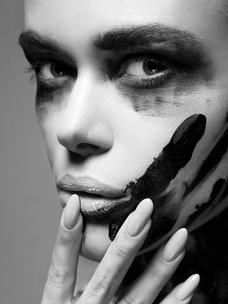 Beautiful woman with Dirty Paint Face. paint over a face and Body. Girl in Black Paint - Photo, Image