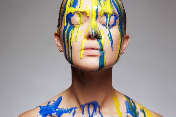 Цветной портрет девушки в краске. жидкая краска течет по красивому лицу и телу. Цвета
 - Фото, изображение