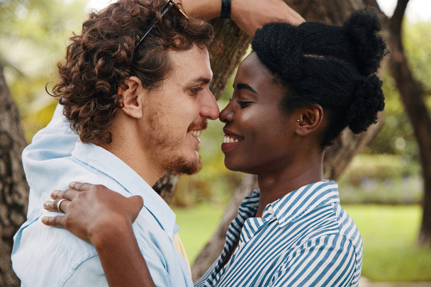 Black woman and Caucasian man in love in park - Zdjęcie, obraz