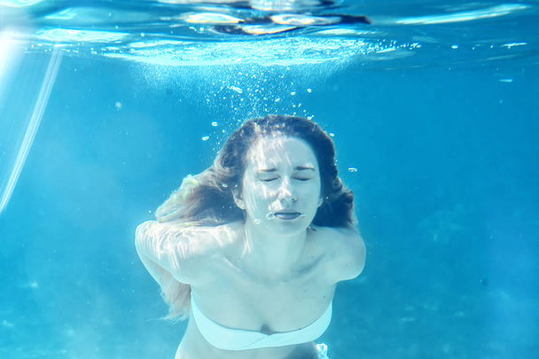 女の子の水泳水中の肖像画。海夏青い水ライトの泡日当たりの良いレイ背景 - 写真・画像