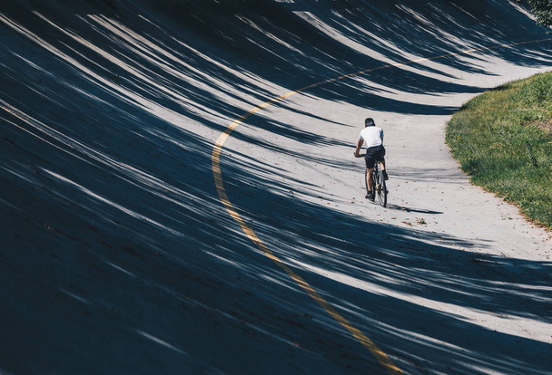 Rowerzysta z rowerowych wzdłuż ścieżki w starego toru, paraboliczne we Włoszech toru wyścigowego Monza - Lombardia - speedway - Zdjęcie, obraz