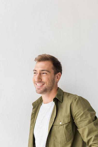 smiling man looking away against white wall - Zdjęcie, obraz