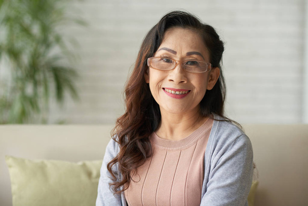 Retrato de asiático sorrindo mulher madura sentada em casa
 - Foto, Imagem