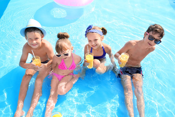 Cute children with glasses of juice in swimming pool on summer day - Foto, Imagem