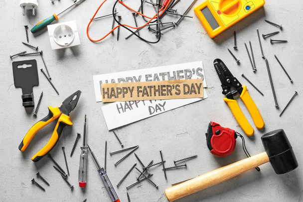 Diferentes ferramentas e papéis com texto "Feliz Dia do Pai" em fundo claro
 - Foto, Imagem