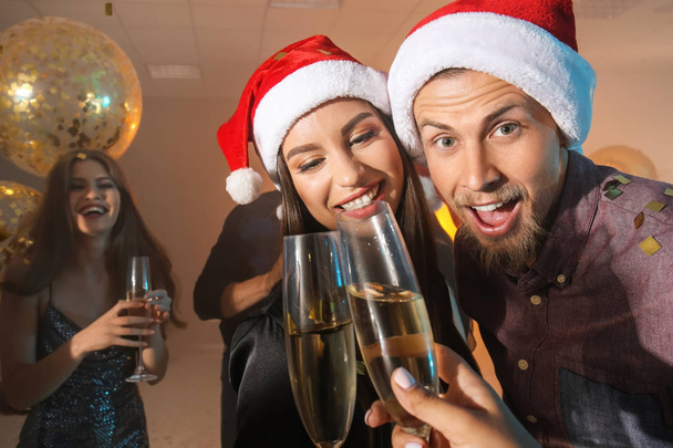 Jongeren met glazen champagne op kerstfeest - Foto, afbeelding