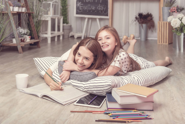 Mutter & Tochter zusammen im Wohnzimmer, kleines Mädchen glücklich, zu Hause mit Mama zu lernen - Foto, Bild