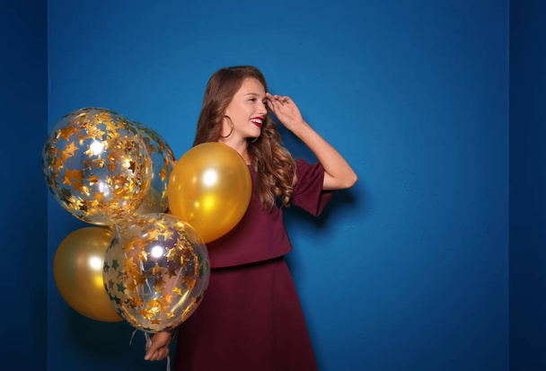 Красива молода жінка з повітряними кулями на кольоровому фоні
 - Фото, зображення