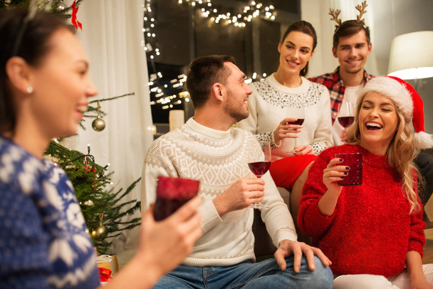 friends celebrating christmas and drinking wine - Фото, изображение