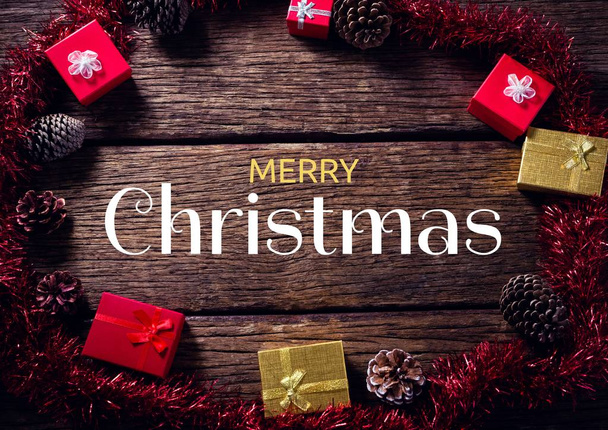 Digital composite of Merry Christmas text with gifts on wood - Foto, Bild