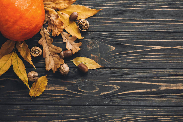 こんにちは秋。明るい秋の美しいカボチャの葉、どんぐり、木の素朴なテーブル上のナッツ。幸せな感謝祭のコンセプト、フラットが横たわっていた。テキストのためのスペース。秋の季節の挨拶状. - 写真・画像