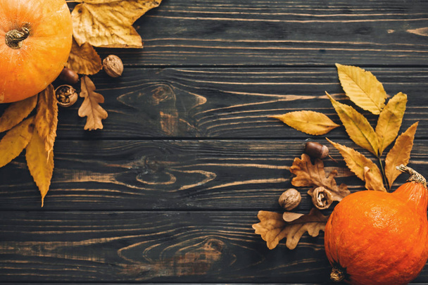 幸せな感謝祭のコンセプトです。カボチャ、秋野菜のカラフルな葉、どんぐり、ナットの美しい構図は、木製の素朴なテーブル、フラットに果実が横たわっていた。テキストのためのスペース。秋のシーズン - 写真・画像