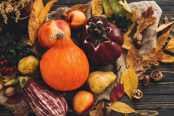 Beautiful Pumpkin, vegetables on bright autumn leaves, acorns, nuts on wooden rustic table. Space for text. Fall season greeting card. Atmospheric Flat Lay. Happy Thanksgiving concept. - Photo, Image