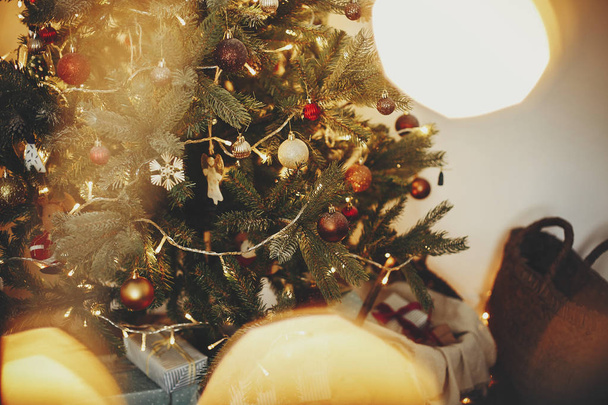 Gyönyörű karácsonyfa díszek, arany fények, és bemutatja az ünnepi szoba. piros és arany golyó fenyő fa ágai. dekoráció a téli ünnepek. légköri pillanat - Fotó, kép