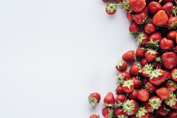 top view of pile of strawberries on white surface with blank copy space - 写真・画像