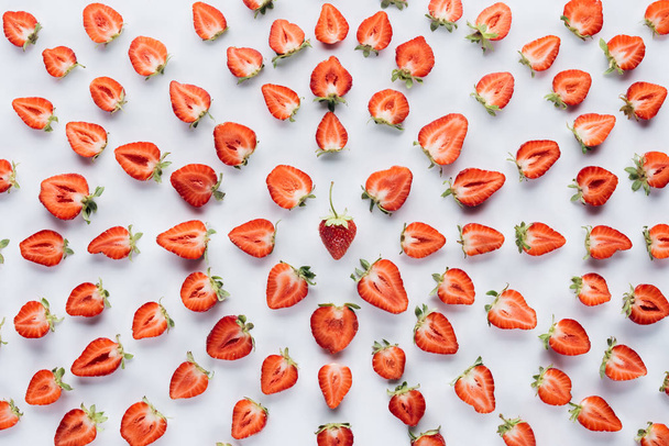 top view of round composition made of halved strawberries on white surface - Fotó, kép