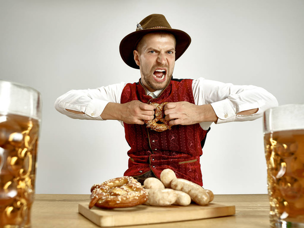 Germany, Bavaria, Upper Bavaria, man with beer dressed in traditional Austrian or Bavarian costume - Fotografie, Obrázek