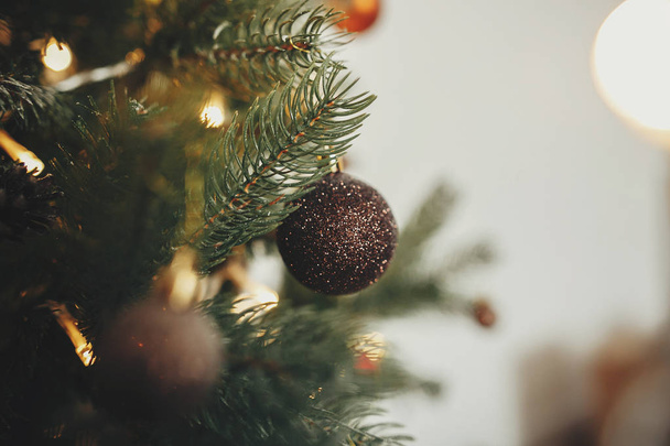 όμορφο χριστουγεννιάτικο δέντρο με φώτα στολίδια, χρυσά glitter σε εορταστική δωμάτιο. χρυσό μπάλες σε κλαδιά δέντρων πεύκων. διακόσμηση για χειμερινές διακοπές. ατμοσφαιρικό ξενοδοχείο - Φωτογραφία, εικόνα