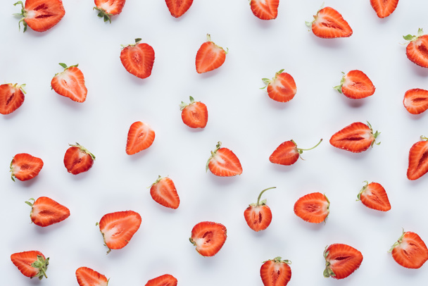 top view of juicy halved strawberries on white surface - Φωτογραφία, εικόνα