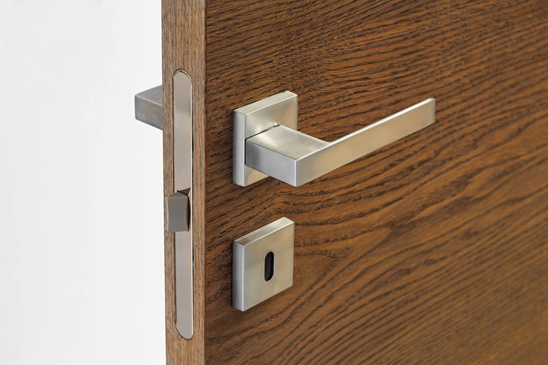Modern metal door handle on wooden door texture - Foto, immagini