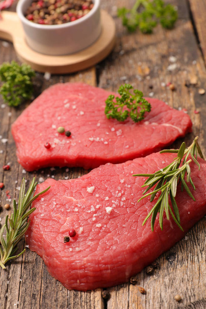 Gyógynövények és fűszerek nyers piros marha steakek - Fotó, kép