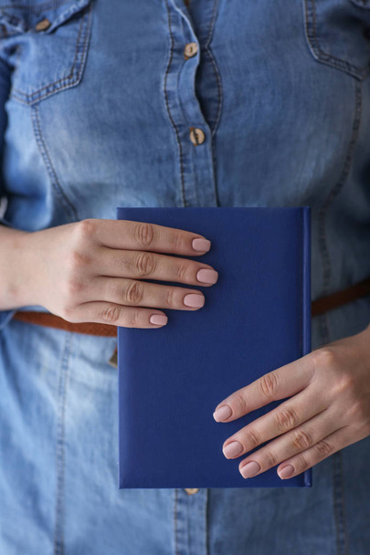 Woman with professional manicure holding notebook, closeup - Фото, зображення