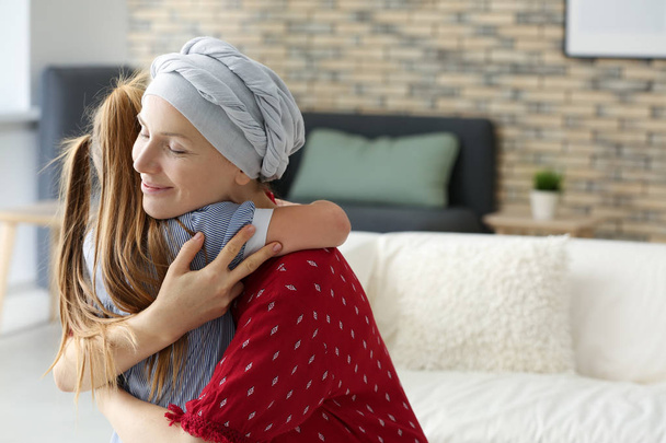 Woman after chemotherapy hugging her daughter at home - Photo, Image