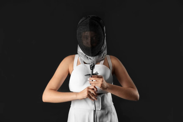 Joven esgrimista femenino sobre fondo oscuro
 - Foto, imagen