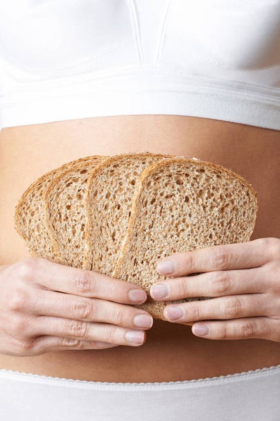 Close Up Of Woman Wearing Underwear Holding Slices Of Brown Bread  - Photo, image