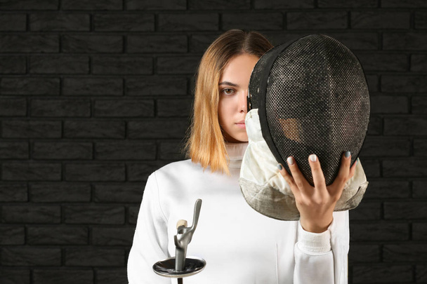 Mladá žena šermíř na tmavém pozadí - Fotografie, Obrázek