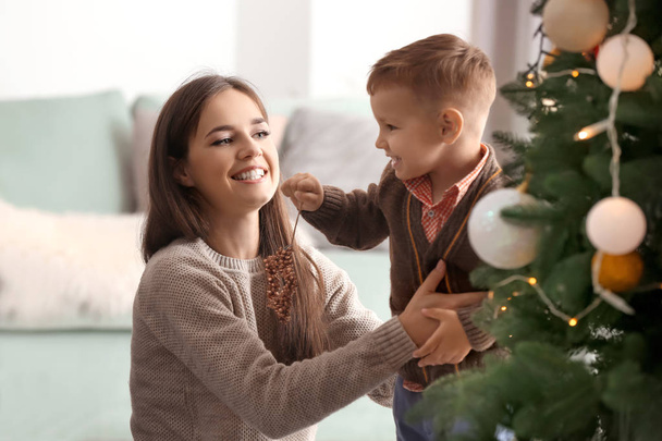 Kleiner Junge und seine Mutter in der Nähe des Weihnachtsbaums - Foto, Bild