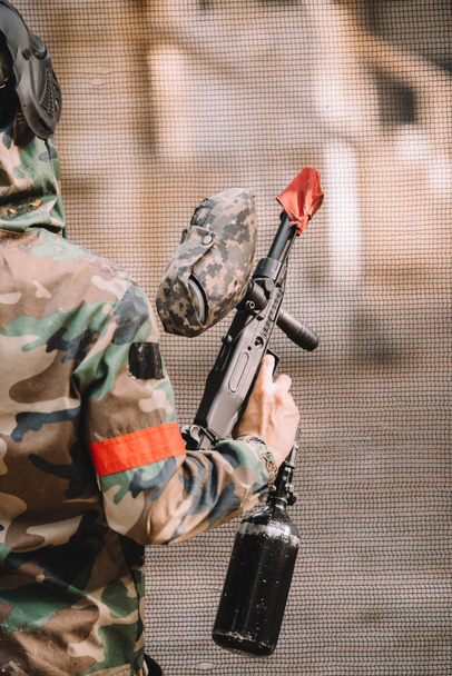 ゴーグル マスクと屋外のペイント ボール銃を保持している迷彩男性 paintball プレーヤーの部分的なビュー  - 写真・画像