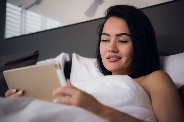 Nő használ digitális tábla az ágyban otthon - Fotó, kép