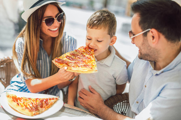 Портрет счастливой семьи, проводящей время в пиццерии
 - Фото, изображение