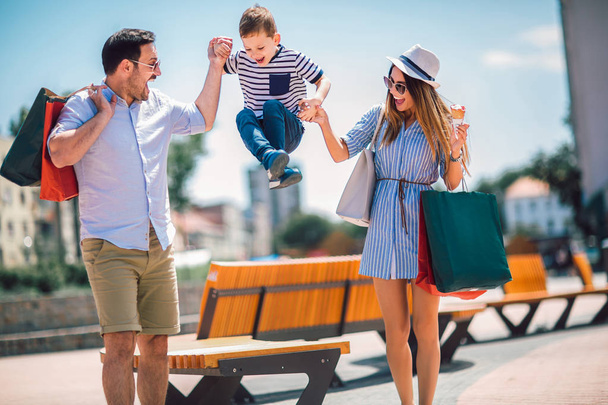 glückliche Familie, die nach dem Einkaufen Spaß im Freien hat - Foto, Bild