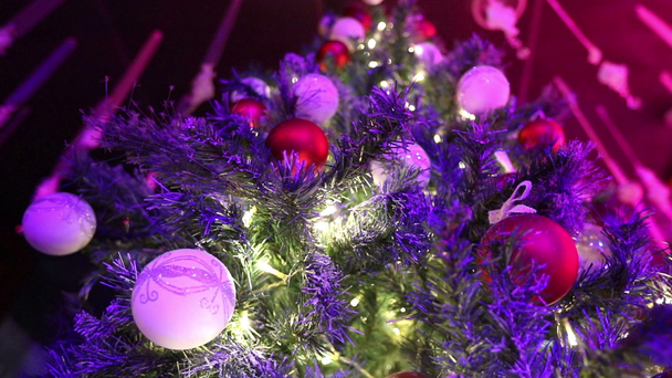 Kerst disco in het restaurant, een kerstboom op de achtergrond van een disco, dansen silhouetten van mensen, licht stralen,, kerstboom met speelgoed, een feestzaal - Video