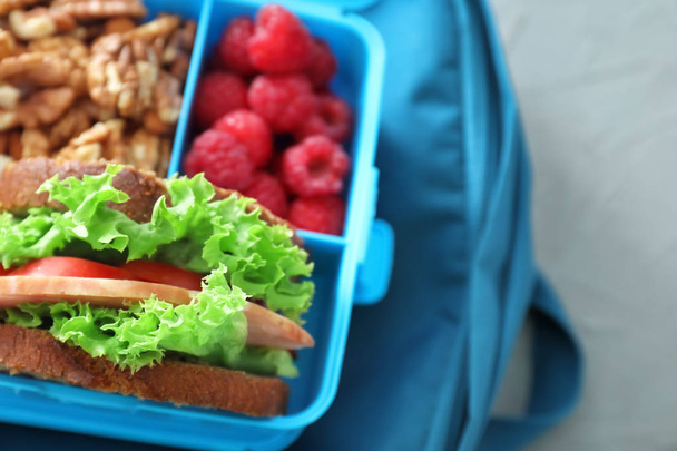 Boîte à lunch avec nourriture appétissante sur sac, gros plan
 - Photo, image