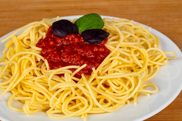 Pasta spghetti Boloñesa servido albahaca
 - Foto, imagen