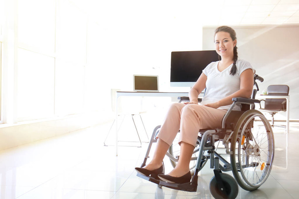 Asian woman in wheelchair in office - Valokuva, kuva