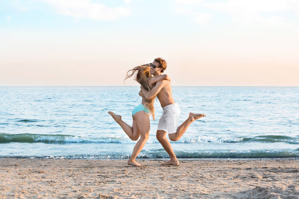 Boldog fiatal pár szórakozik a tengerparton - Fotó, kép