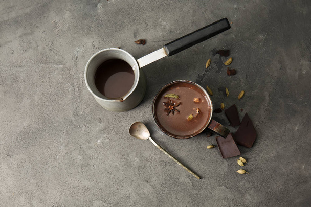 Cezve en kopje warme chocolademelk op grijze tafel - Foto, afbeelding