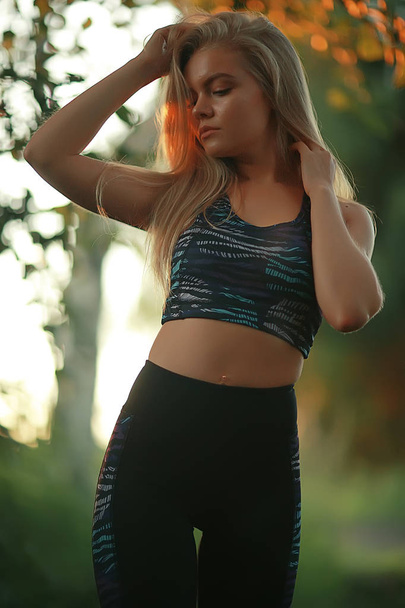 beautiful young woman wearing sportswear in summer park, jogging and sport concept  - Фото, изображение