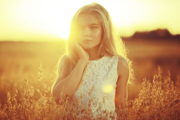 beautiful young woman in rural field at sunset, summer vacation - Фото, зображення