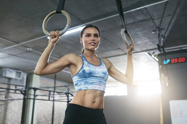Vrouw fitnesstraining met gymnastiek ringen bij Crossfit Gym - Foto, afbeelding