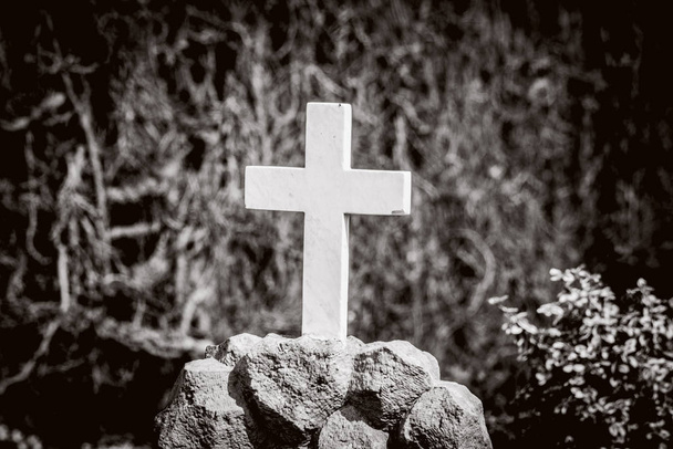 Cruz branca em um túmulo em cores sépia em um cemitério
 - Foto, Imagem