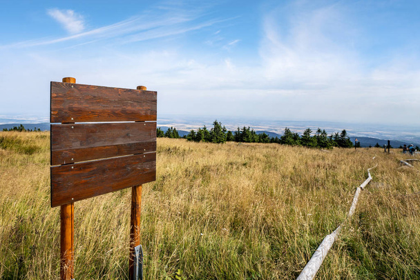 Wooden multi sign on the top of a hill with golden grass in the summer - Photo, Image
