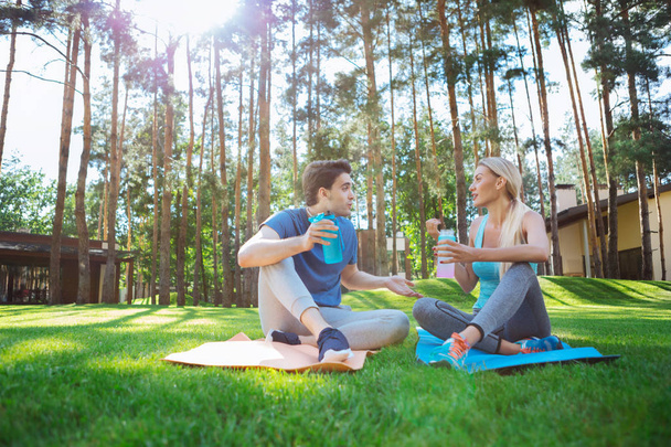 Positive young people relaxing on yoga mats - Foto, Bild