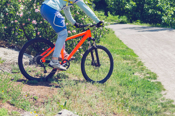 Un ciclista en una bicicleta naranja está conduciendo todo terreno
. - Foto, imagen