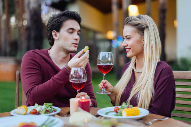 Delighted positive young couple drinking wine together - Foto, afbeelding