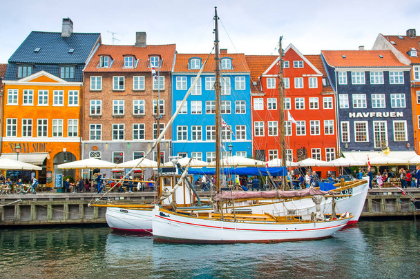Koppenhága, Dánia - 2018. augusztus 29.: színes házak és hajók a csatorna-a Nyhavn töltésén  - Fotó, kép